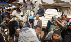 A Palestinian carries a sack of flour received from the United Nations Relief and Works Agency (UNRWA) headquarters in Rafah refugee camp in the southern Gaza strip December 2, 2009. REUTERS/Ibraheem Abu Mustafa (GAZA POLITICS)